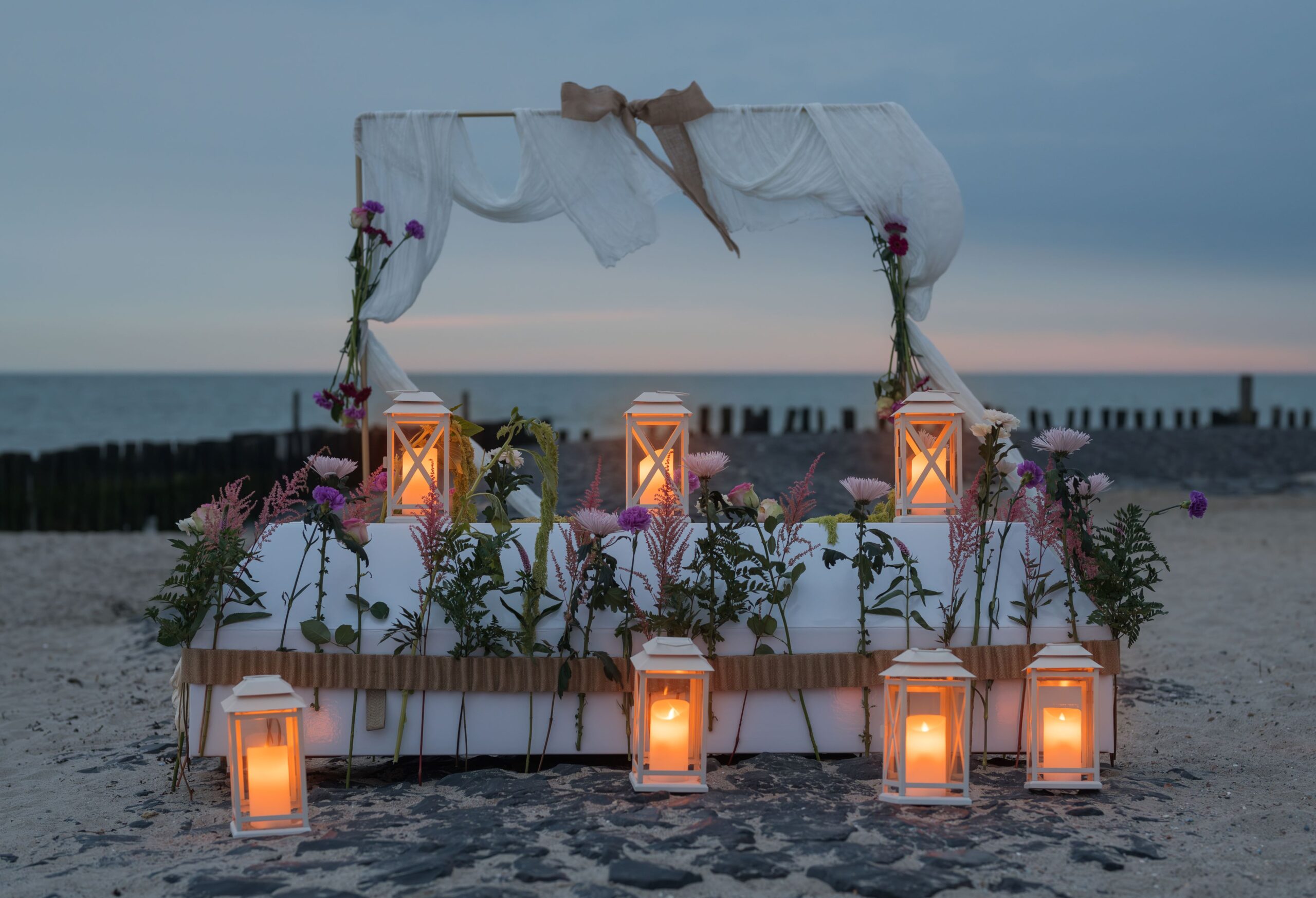 Kist met bloemen op het strand scaled